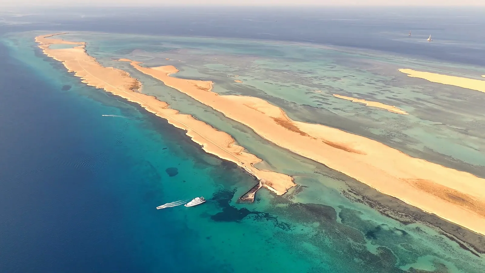 Sandbanks and reefs from a drone, a yacht nearby